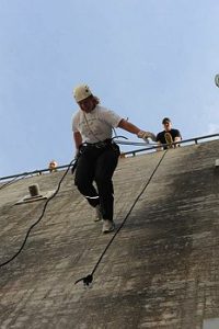 Kvinde igang med australsk rappelling på Muren.