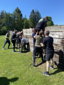 Deltager hjælper hinanden over en mur